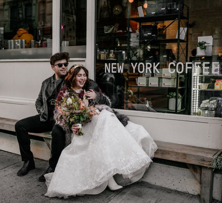 Bride & groom sit back outside shopfront in New York 