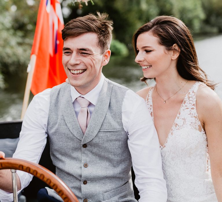 Groom steers boat with bride sat next to him 