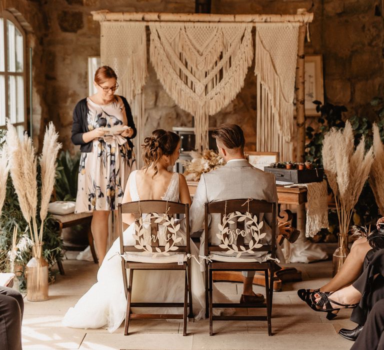 Bride and Groom at rustic boho wedding ceremony with pampas grass