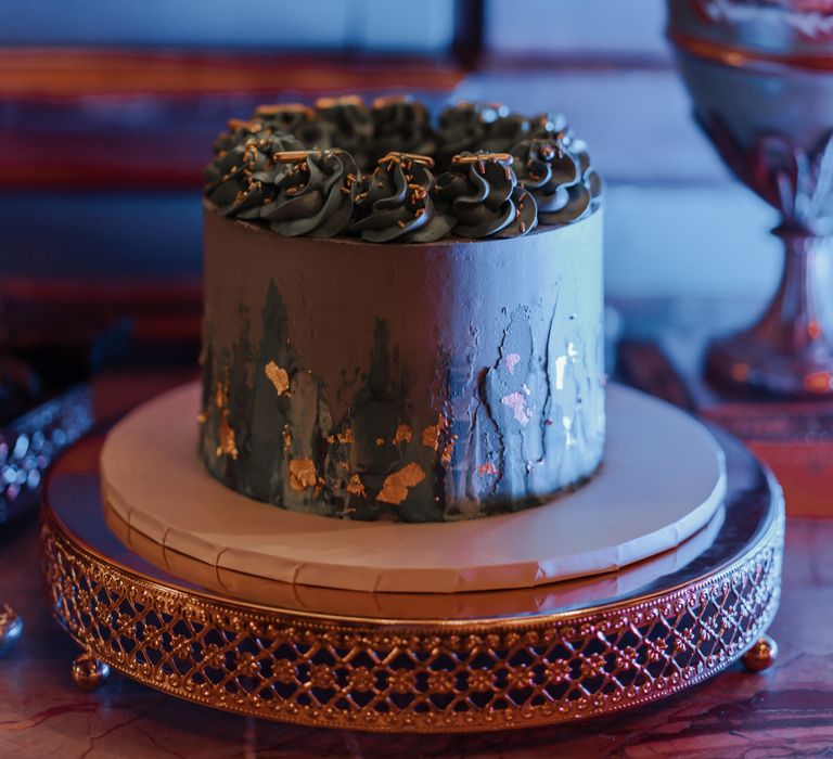 Wedding cake featuring gold leaf decoration against black frosting 