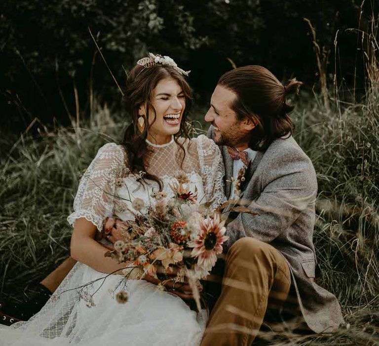 Bride and groom laughing in The Willow Tree's back garden meadow