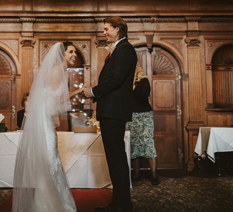 Bride and groom laughing at the altar at their Rhinefield House wedding 