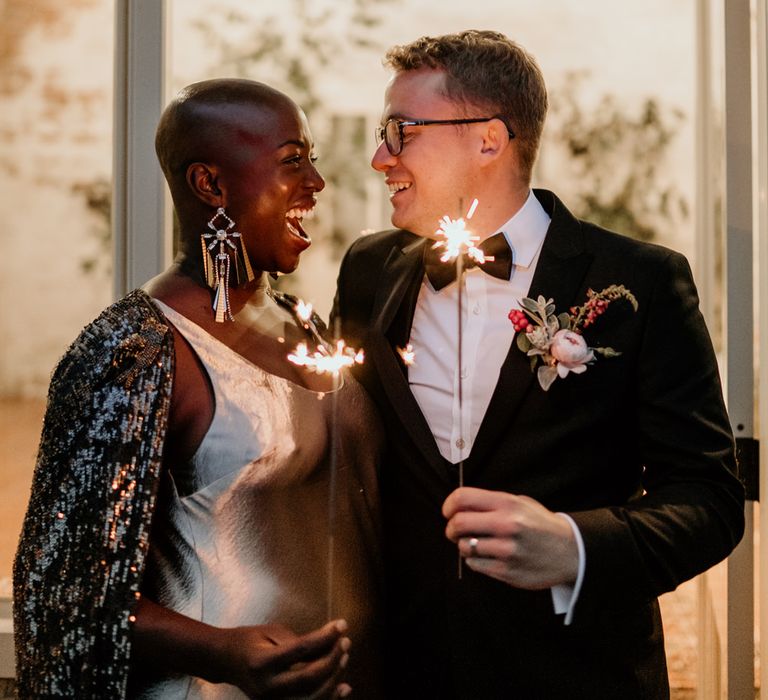 Sparkler moment with bride with alopecia wearing a black glitter bridal cape and Tilly Thomas lux statement earrings 