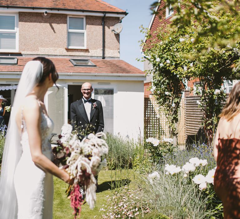 Bride stands in the garden wearing Enzoani wedding gown