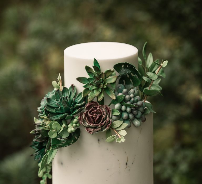 White frosted two tier cake with green floral decor