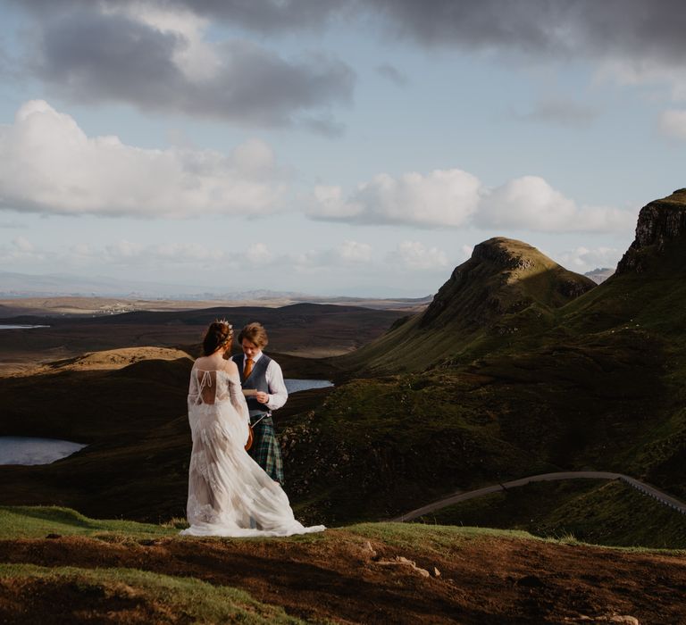 Bride & groom stand on the hillside 