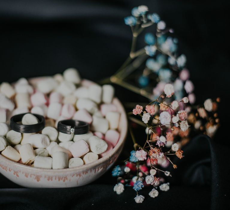 Black wedding rings in a bowl of marshmallows 