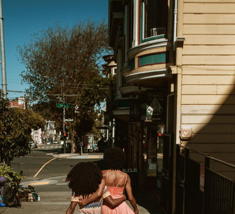 Two brides-to-be walking arm in arm along the streets in San Francisco 