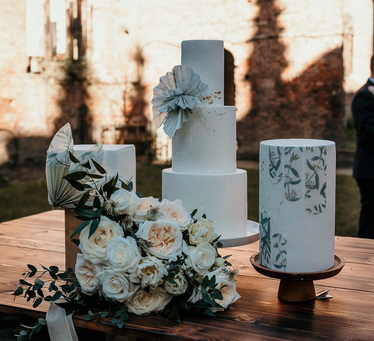 Three buttercream wedding cake designs with square and round layers and floral decor 