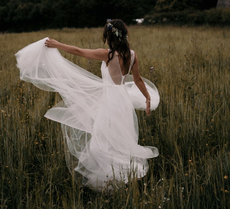 Bride twirls around in fields as her dress swirls around her