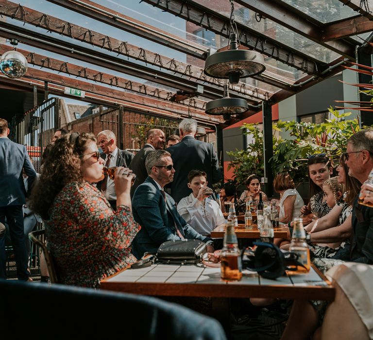 Wedding guests sit during wedding reception at Horticulture outdoors