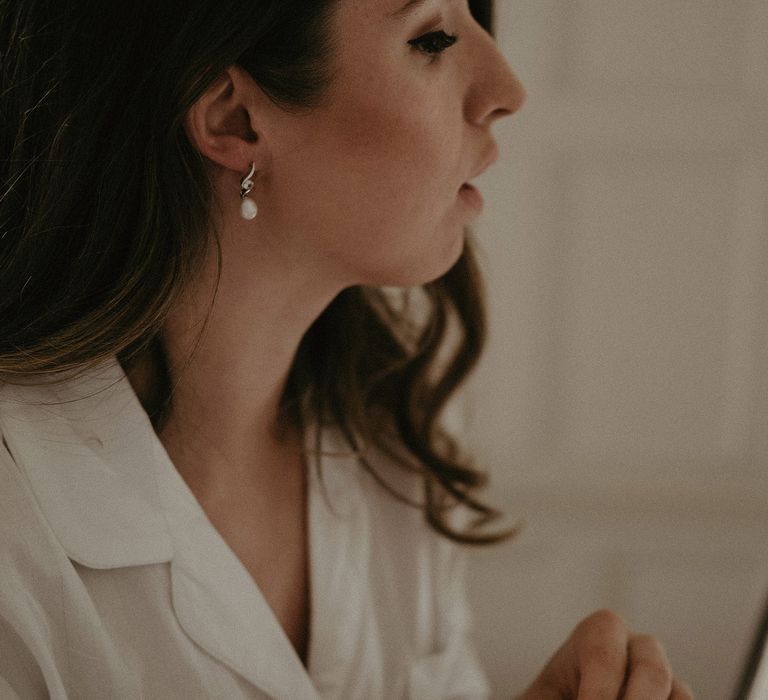 Bride wears her brown hair in loose curls on the day of her wedding