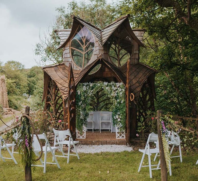 Gothic fairy-style house wedding arch complete with chairs to line the aisle