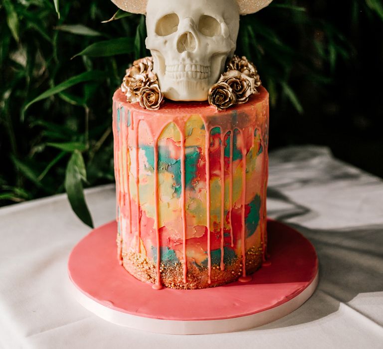 Colourful tall single tier drip wedding cake with skull and Mickey Mouse ears wedding cake topper 