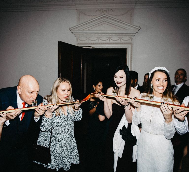 Bride does shot ski with groom and guests