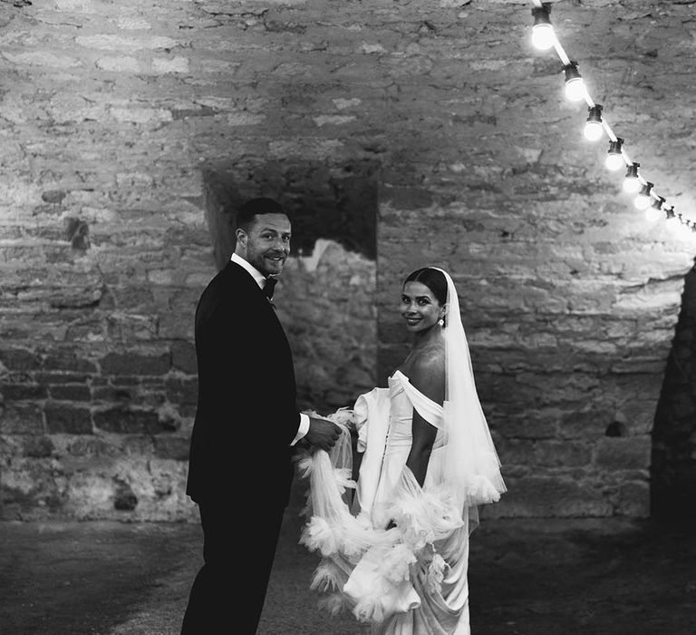 Bride & groom stand with one another in black & white image on their wedding day