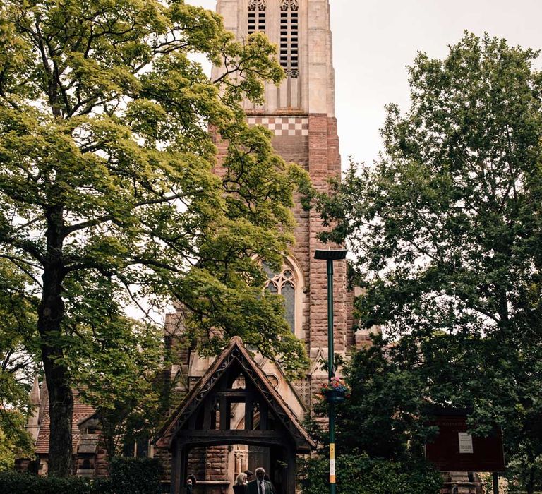 Groom in blue and white vintage wedding car gets out at the church before wedding ceremony