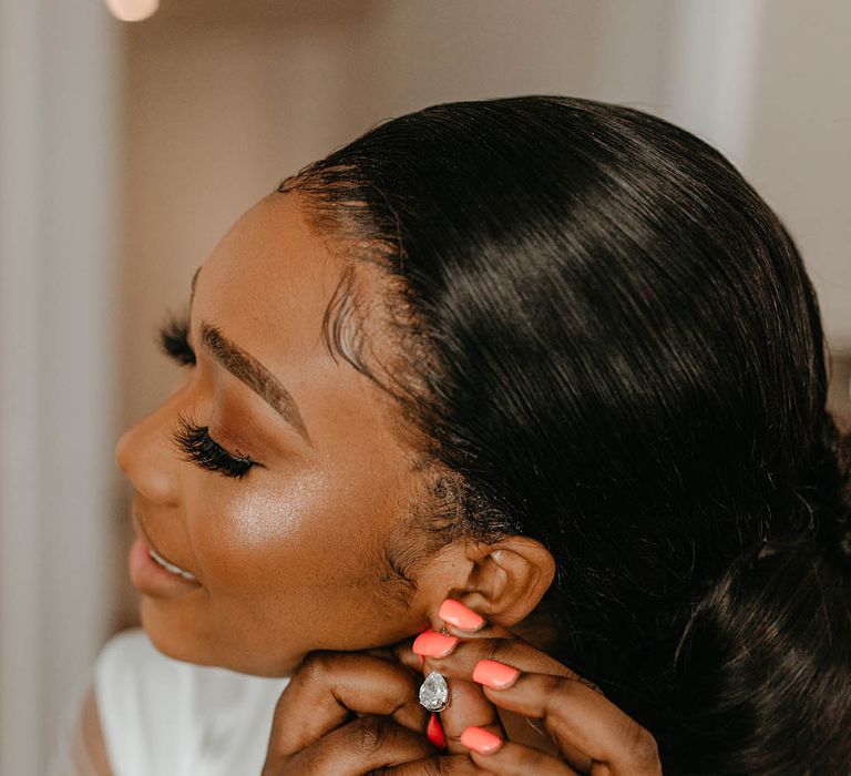 Bride puts her earrings in on the morning of her wedding day