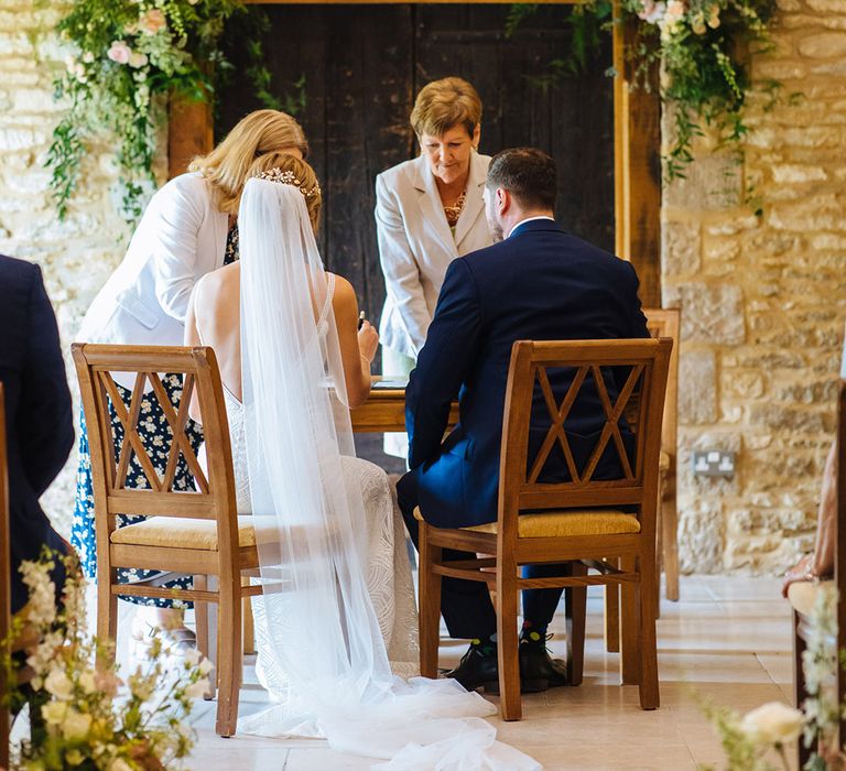 Bride and groom signing the register at their Caswell House wedding ceremony 