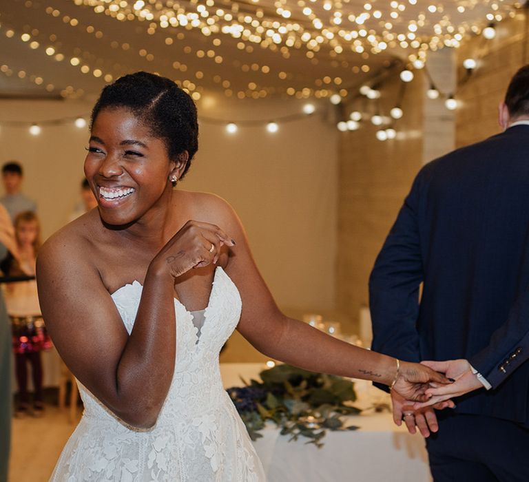 Bride smiles with stunning simple make up wearing sweetheart lace wedding dress