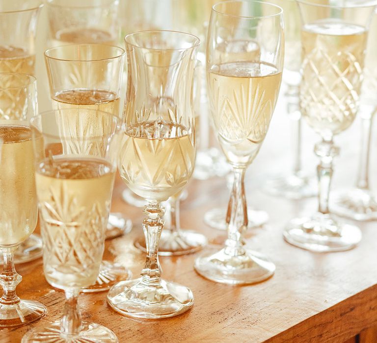 Various and mismatched crystal glasses filled with alcoholic beverages 