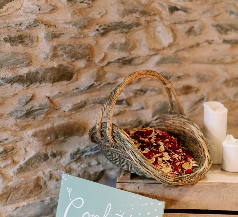 Confetti sign with wicker basket full of confetti for wedding guests to throw over the couple