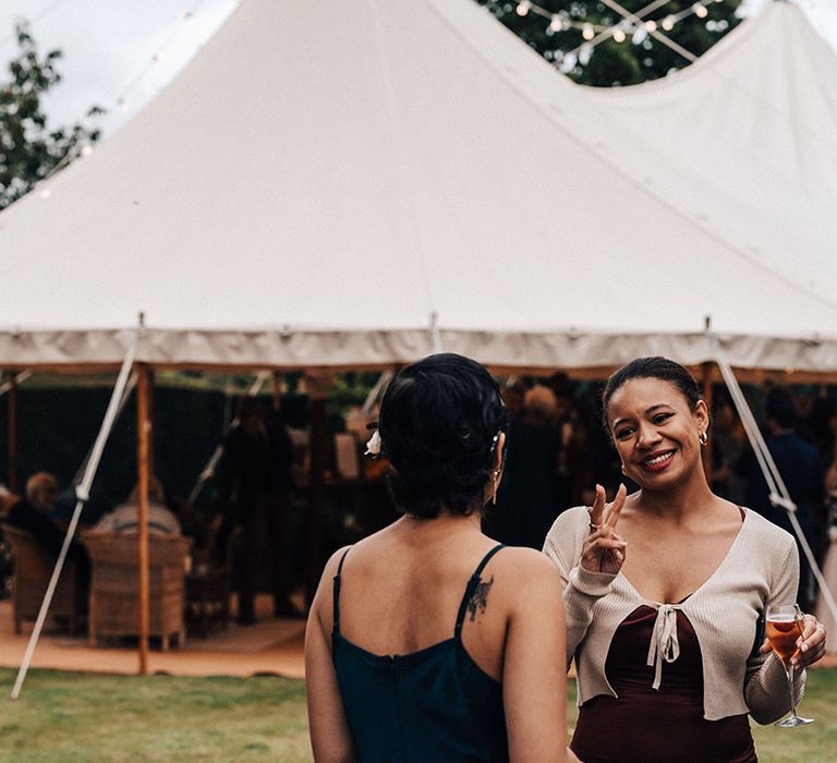 Wedding guests outside tipi for wedding reception at outdoor wedding