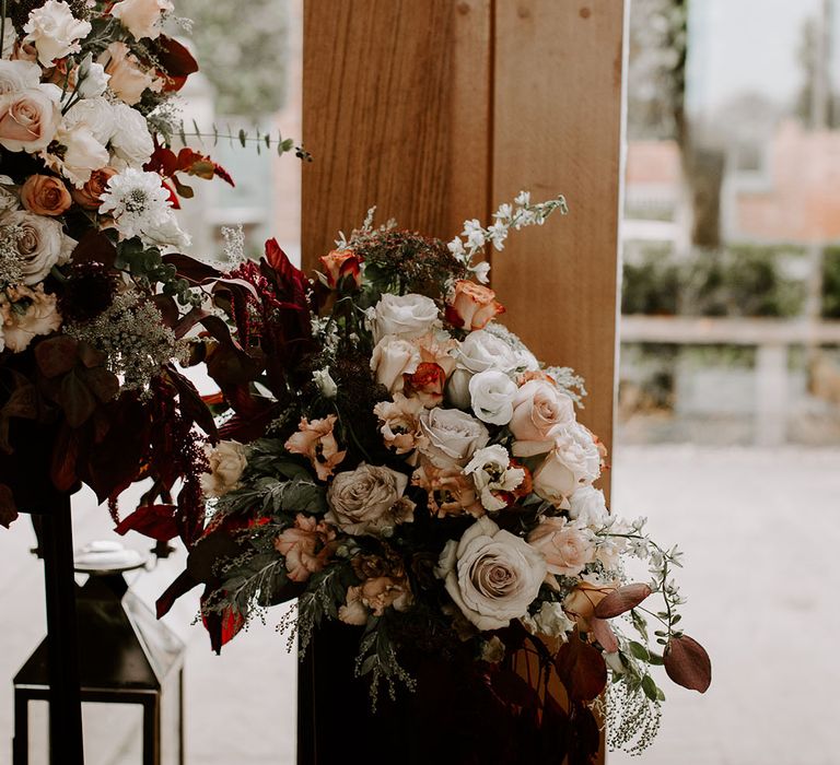 Autumnal flower arrangement with autumnal tones including roses and bridal wreath