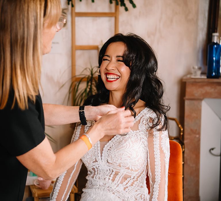 Bride in lace wedding dress with red lip gets hair done for the wedding day 