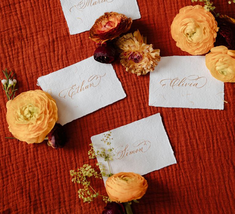 Name place cards written in gold calligraphy