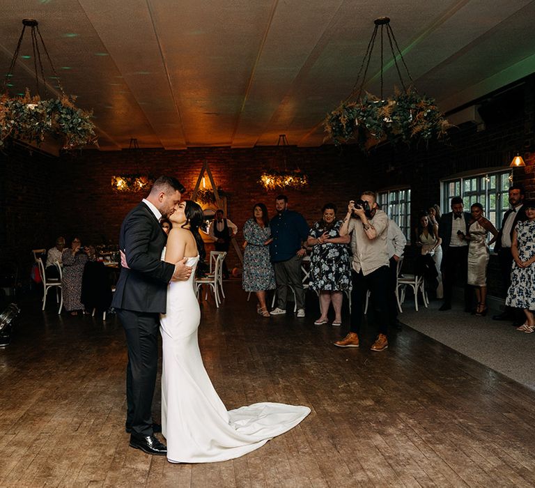 Bride and groom share their first dance together as the wedding band plays 