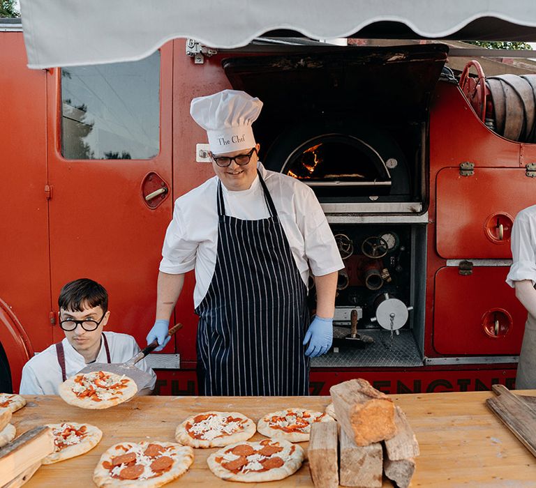 Chefs handmake pizzas to serve to the wedding guests 