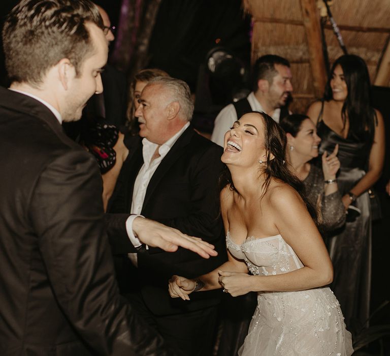 Bride laughs and dances with her husband outdoors during rave wedding reception 