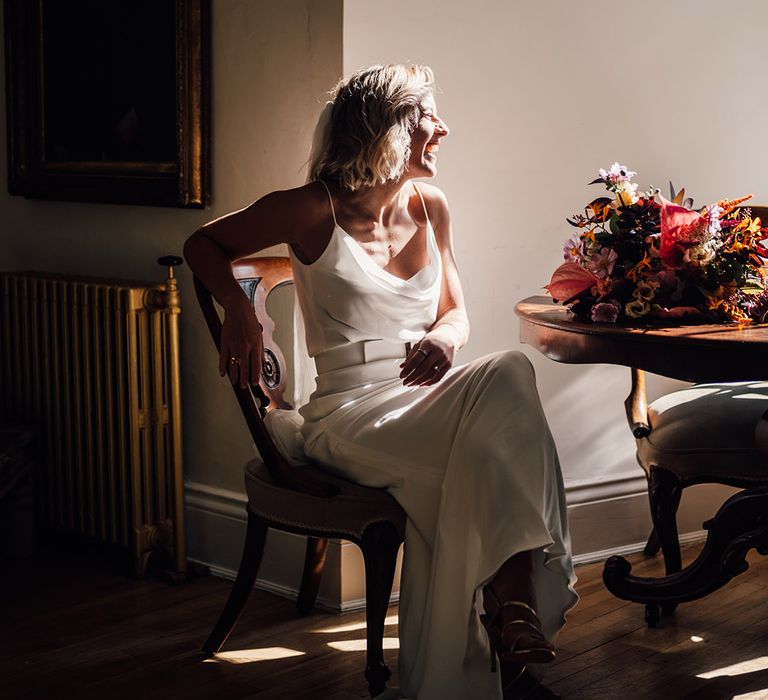 Bride wears cowl neck silk slip wedding dress with belt and cathedral veil 