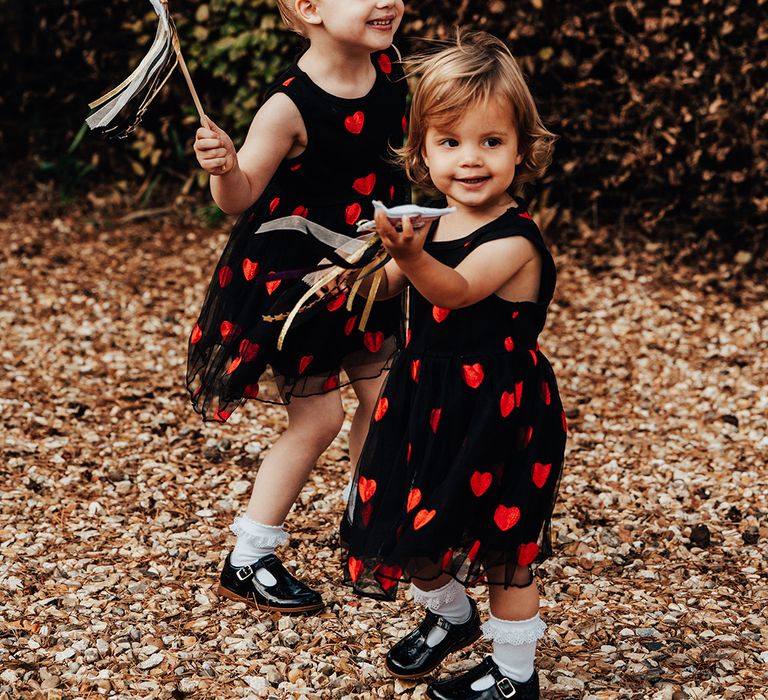 Two flower girls in black and red heart patterned dresses for the gothic wedding 