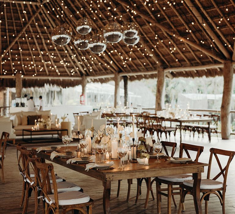 blue venado beach wedding reception with glitter balls, candles and fairy lights decorating the Mexican palapa hut