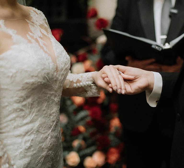 The groom puts on the bride's wedding ring with ombre silver chrome wedding nails 