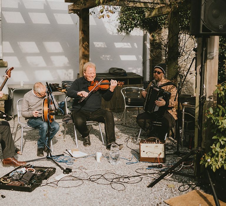 A live wedding band plays outside for the welcome drinks and canapés 