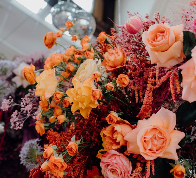 Suspended colourful wedding flowers with peach, pink and blush garden roses, dried flowers and foliage 