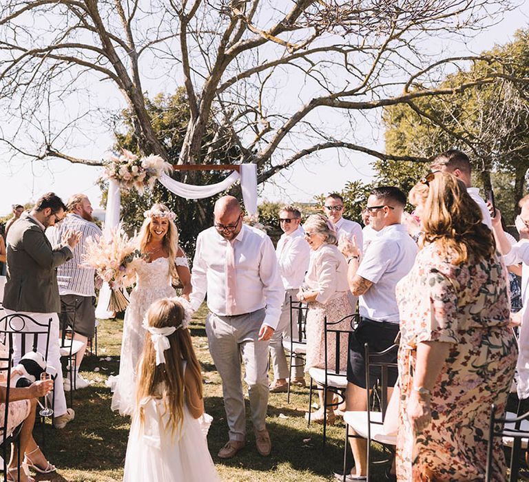 Outdoor wedding in Croatia with the bride and groom walking back down the aisle as a married couple 