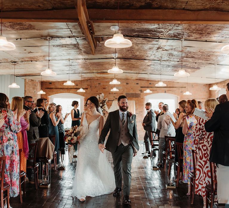 The bride and groom walk back down the aisle as a married couple at The West Mill wedding venue 