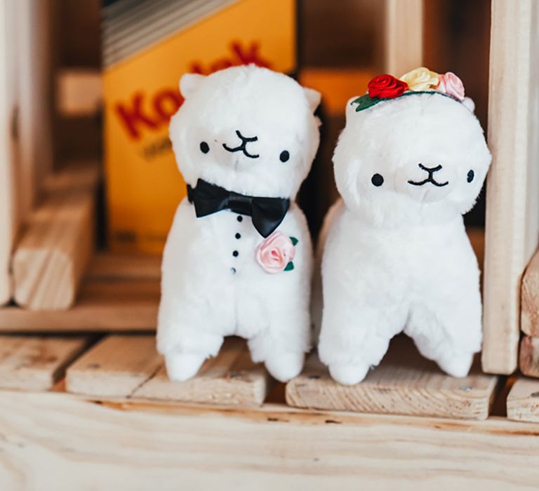 Two llama cuddly toys dressed as the bride and groom 