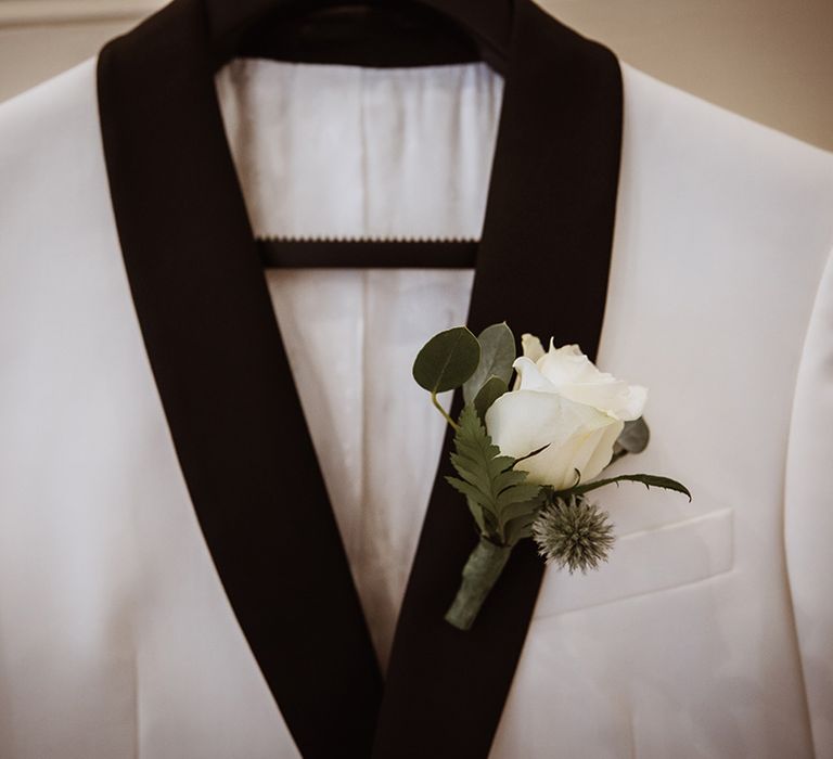 White and black wedding tuxedo with white rose buttonhole accessory 