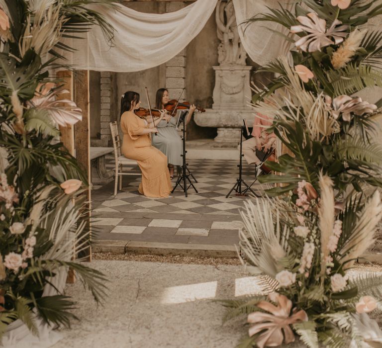 Wooden frame decorated with drapes and tropical flowers 