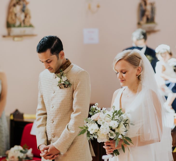 Bride and groom praying at micro wedding 