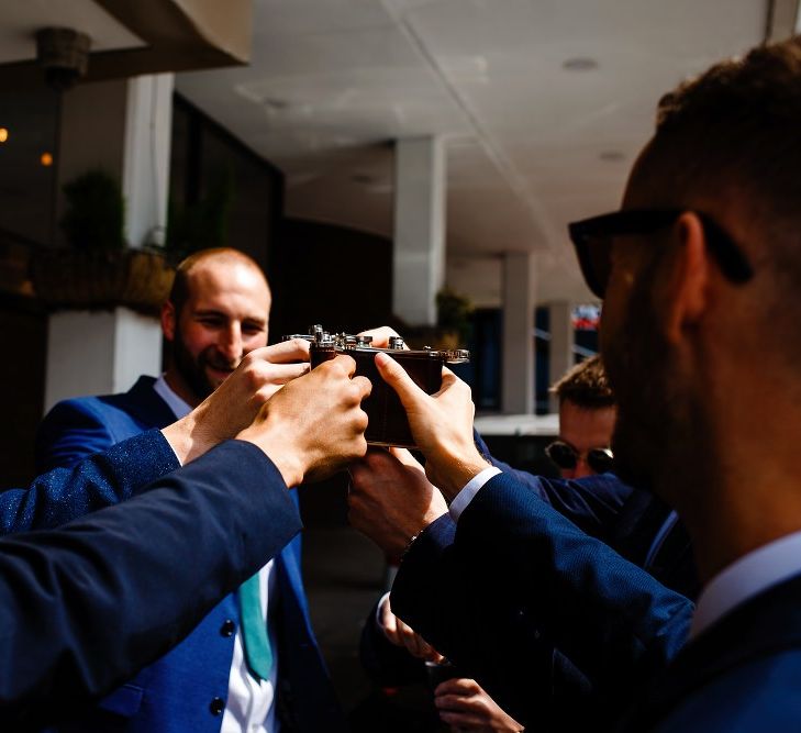 Groomsmen drinking from their hip flasks 