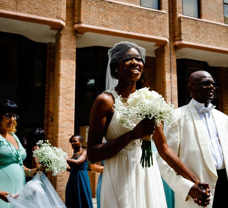 Father of the bride in white dinner jacket holding his daughter hand