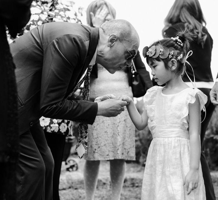 Flower girl holding hands with wedding guest