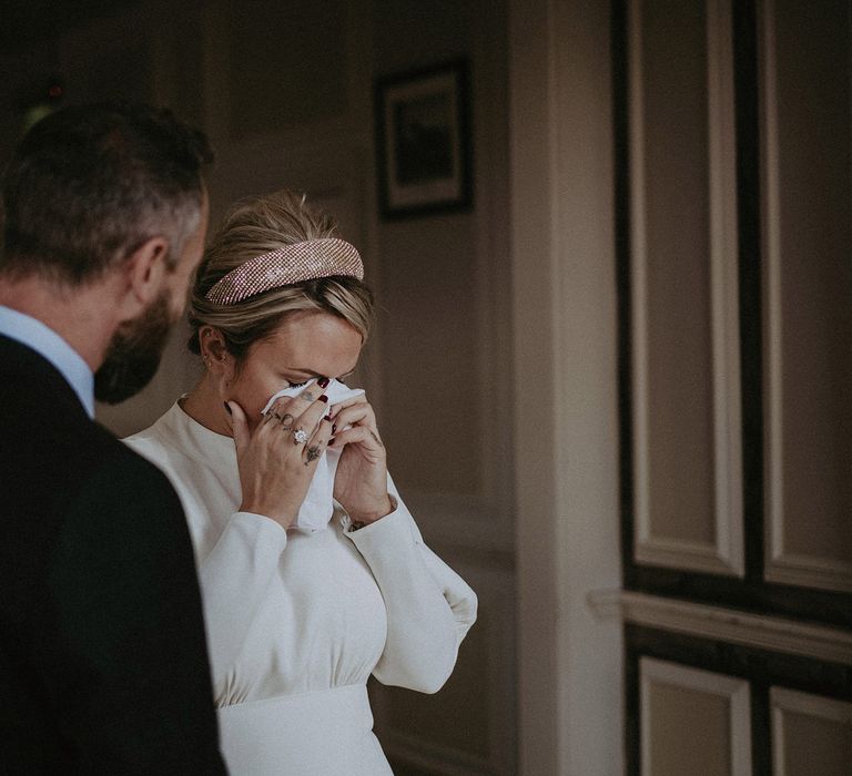 Emotional bride with dark red nails at the wedding ceremony 