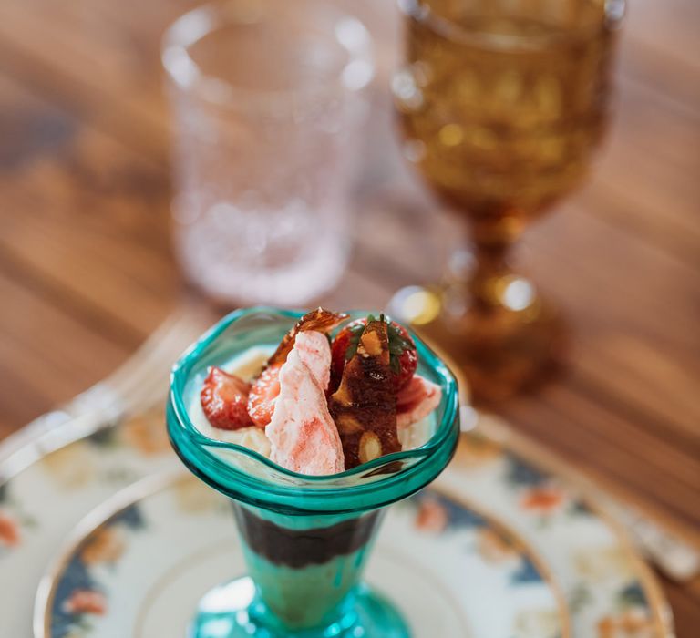 Ice-cream sundae in coloured glass serving dish 